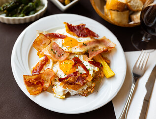 Delicious breakfast — scrambled eggs with bacon and french fries