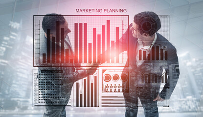 Two professionals collaborate in a modern office environment, engaging in marketing planning while analyzing data visualizations and charts. Impute