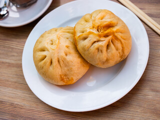 Traditional Chinese steamed buns Xiaolongbao stuffed with minced pork and vegetables served on...
