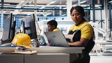 Black woman technician testing solar panel designs on industrial software, working in alternative...