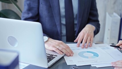 Two professionals analyzing a pie chart during a strategic business meeting. Business meeting with graph analysis