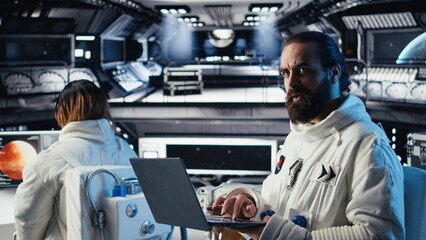 Astronaut using laptop to verify mission parameters after completing planet surface expedition. Cosmonaut manages systems using notebook, leaving Mars, updating flight log to return home
