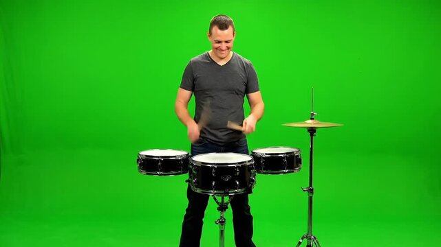 Energetic drummer performing on green screen backdrop, perfect for music videos or creative projects, bringing rhythm and passion to your visuals