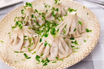 On plate is portion of hinkali, traditional dish of Georgian cuisine made from dough and minced meat. Gastro impressions after visiting national restaurant, gastronomy
