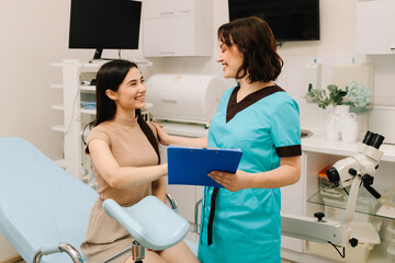 Gynecologist Exam with Colposcopy Equipment. Gynecologist prepares for a pelvic examination with...