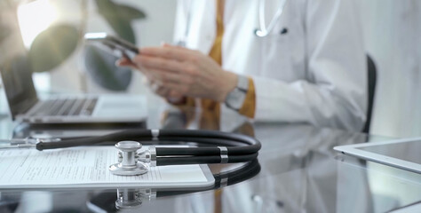 Close-up of doctor's desk with stethoscope and digital tablet in flair medical office. Medicine and health care