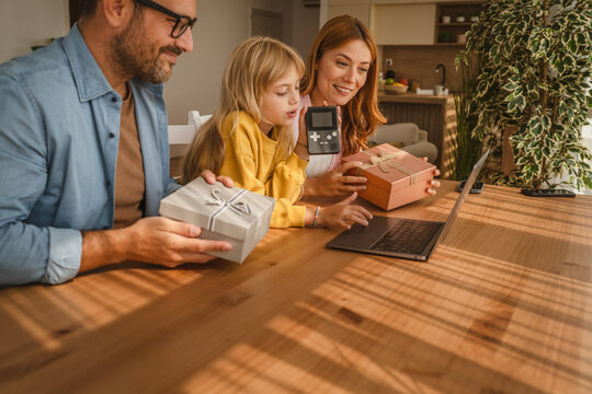 Family celebrating birthday with daughter showing handhold console on video call - Powered by Adobe