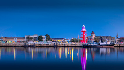View of buildings reflecting in water in the blue hour