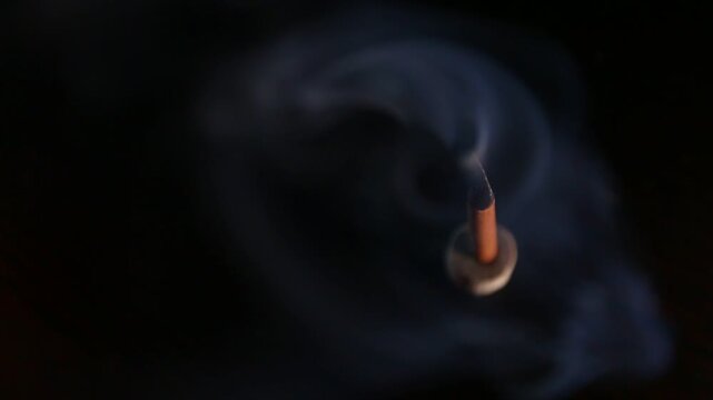 Smoldering aroma incense on dark background with natural atmosphere concept smoke. Magic calm waves from herb incense. Therapy and spa fumigation concept