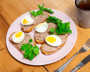 Sandwich with pollock liver, boiled eggs, olives and parsley. Tasty breakfast