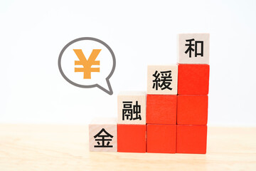 金融緩和のイメージブロックと円マークの吹き出し。