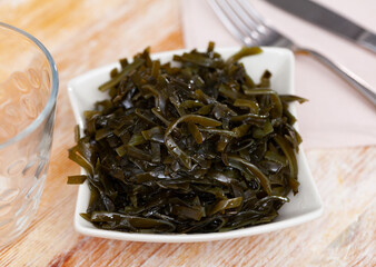 Japanese restaurant serves traditional vegetable appetizer, salad of fresh seaweed.