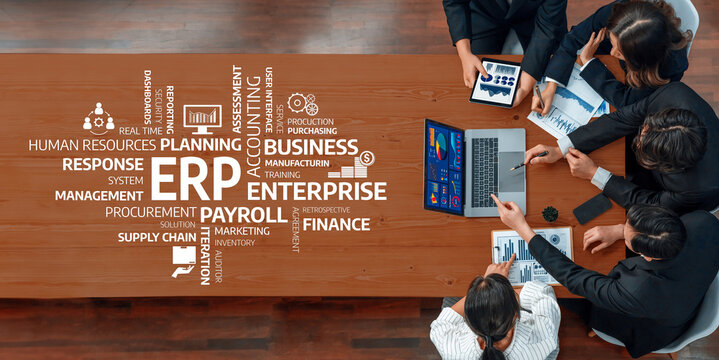 A diverse business team engaged in strategic discussions around ERP implementation, utilizing charts and data visuals on a modern conference table in a professional office setting. Amity