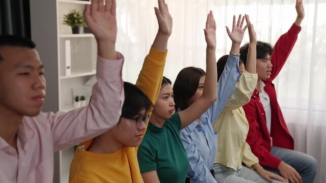 Group of interviewee candidate in colorful casual wearing line up for vacancy interview sitting on the chair. Intern raise hand. Job opportunity recruitment for HR agency and vacancy concept. Synergic