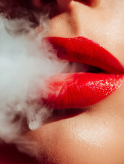 Fototapeta premium Close-up of lips with bold red lipstick exhaling smoke for a dramatic effect