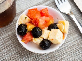 Greek salad, bursting with vibrant Mediterranean flavors, is presented in bowl.