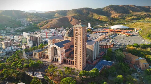aerial view of the Basilica of the National Shrine of Our Lady Aparecida in Brazil during sunrise with mountains and greenery at distance