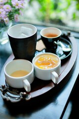 A healthy, hot green tea beverage in a white china teacup with a saucer is ready for a Chinese tea ceremony