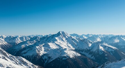 snow-covered mountain peaks under a clear blue sky, featuring a tall central summit surrounded by rugged slopes and deep valleys in a pristine winter landscape.