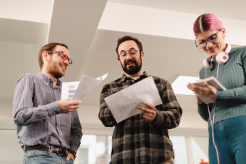 Business meeting with three businesspeople discussing project details in an office setting during the afternoon