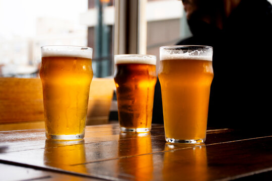 Craft beer logo mockup on 3 pints of ale on bar table