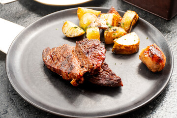 two slices of succulent barbecue served with rustic potato steak cut of beef in a steakhouse