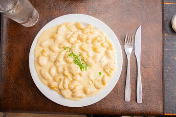 vegan gnocchi dish with four cheese sauce in top view restaurant