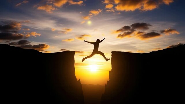 silhouetted person leaps across deep chasm between two dark mountain cliffs A vibrant sunset with bright sun illuminates the sky painting clouds in warm orange and golden hues