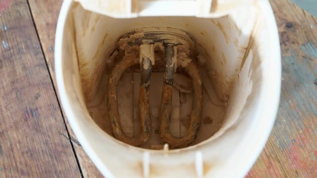 A detailed close-up view of an electric kettle's heating spiral, visibly encrusted with significant limescale deposits. This highlights the common issue of hard water buildup in household appliances.