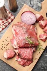 Pieces of raw beef meat and spices on black marble table, top view