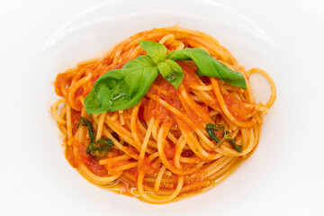 Classic Italian pasta, Spaghetti with tomato sauce and basil on a white plate