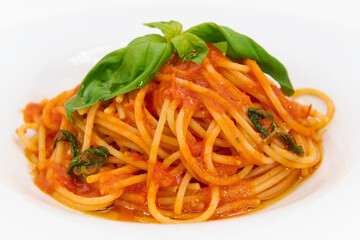 Classic Italian pasta, Spaghetti with tomato sauce and basil on a white plate