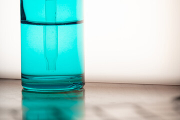 Close-Up of Blue Dermatologic Serum Backlit Bottle – Skincare or Laboratory Concept