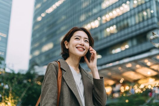 Urban setting phone interaction businesswoman dialogue while networking digital communication app Japan individual with smartphone connecting and chatting with contact smiling