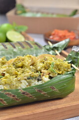 Grilled rice with shredded chicken and green chilies, wrapped in banana leaves, traditional Indonesian food