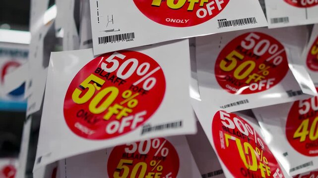 Close-Up View of Discount Tags and Red Sale Stickers on Product Shelves During Black Friday