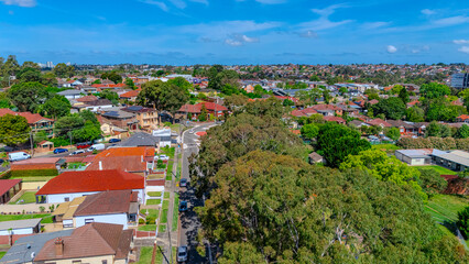 Fototapeta premium Aerial Drone view of Sydney Inner West Sydney Suburb of Ashbury and Croydon with house roof tops, the streets parks and cars in Sydney NSW Australia
