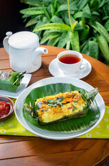 Grilled rice with stir fry chicken, wrapped in banana leaves, traditional Indonesian food