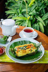 Grilled rice with stir fry chicken, wrapped in banana leaves, traditional Indonesian food
