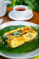 Grilled rice with stir fry chicken, wrapped in banana leaves, traditional Indonesian food
