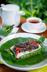 Grilled rice with stir-fried squid, wrapped in banana leaves, a traditional Indonesian dish
