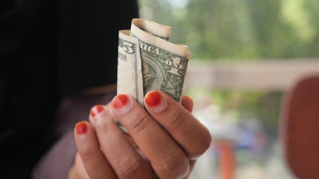 Woman holding a five dollar bill 4k video