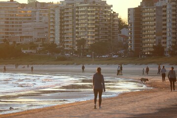 Caminhante solit&aacute;rio na orla de Malv&iacute;n, com pr&eacute;dios ao fundo, Montevid&eacute;u
Lone walker on Malv&iacute;n seafront with city buildings in the background, Montevideo
