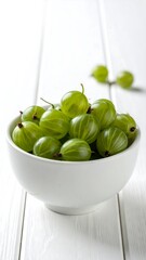 Green gooseberries in white bowl