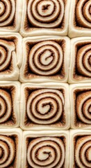 Fototapeta premium Close-up overhead view of freshly baked cinnamon rolls, showing intricate spiral patterns.