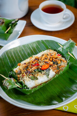 Grilled rice with anchovies and tempeh, wrapped in banana leaves, a traditional Indonesian dish