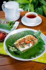 Grilled rice with anchovies and tempeh, wrapped in banana leaves, a traditional Indonesian dish