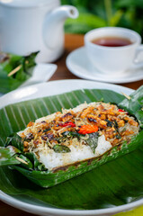 Grilled rice with anchovies and tempeh, wrapped in banana leaves, a traditional Indonesian dish
