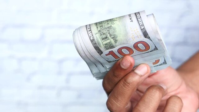 Person holding rolled up 100 dollar bills 4k video
