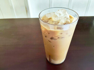 Refreshing Iced Milk Tea or Teh Tarik in a Tall Glass on a Dark Wooden Table